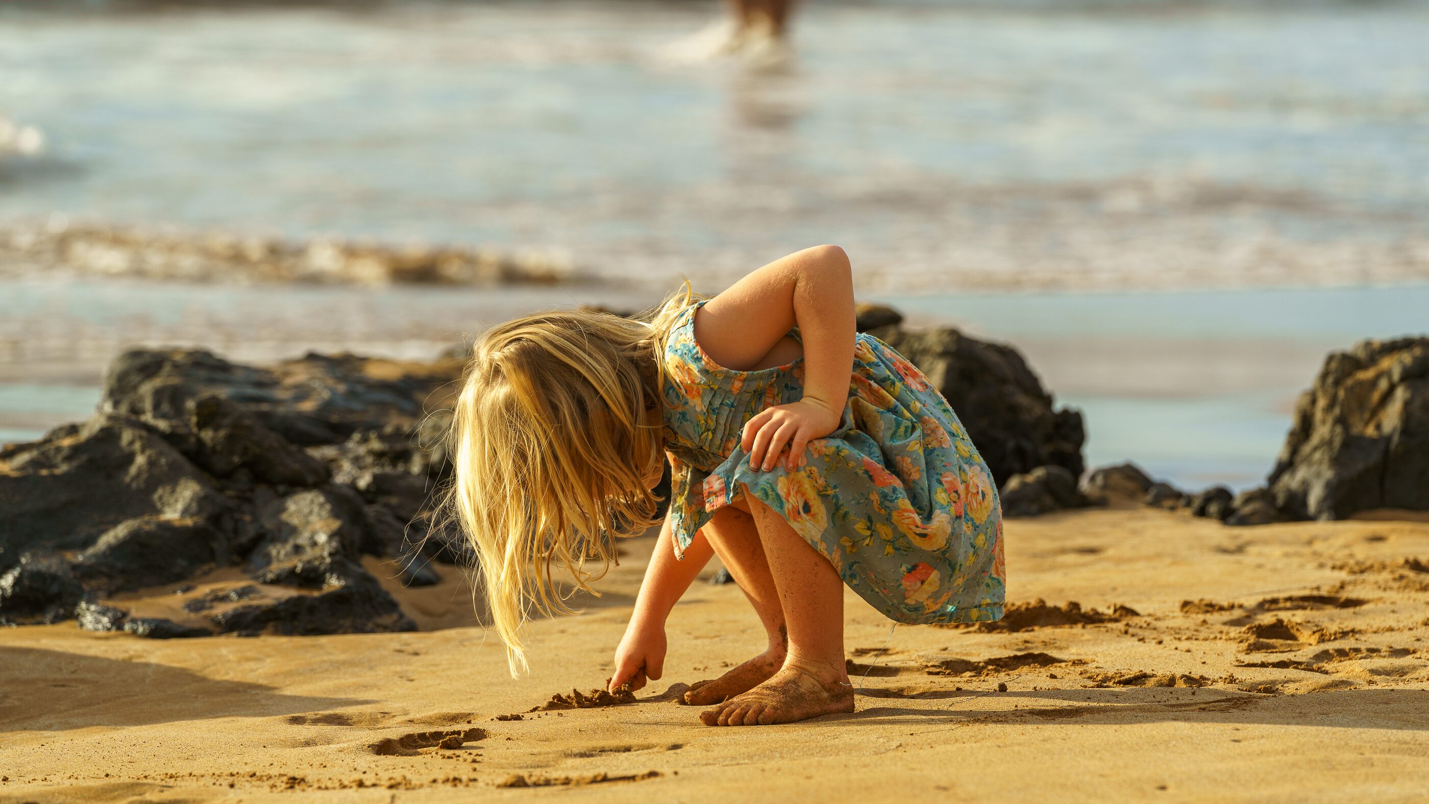 A child playing at the edge of a tropical beach